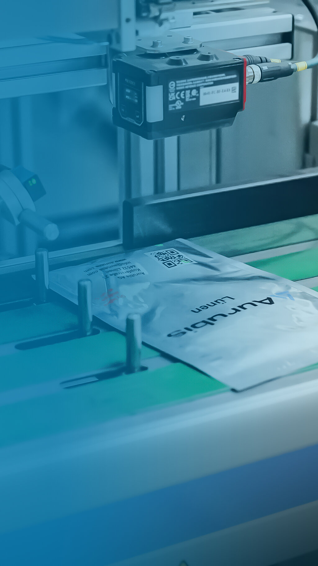 Foto: Aurubis: Ein silberne Tüte mit der Überschrift "Aurubis Lünen" befindet sich auf einem grünen Fließband